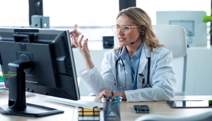 Doctor on computer consulting with patient