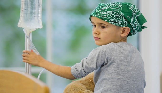 A young boy looking sad as he received chemotherapy