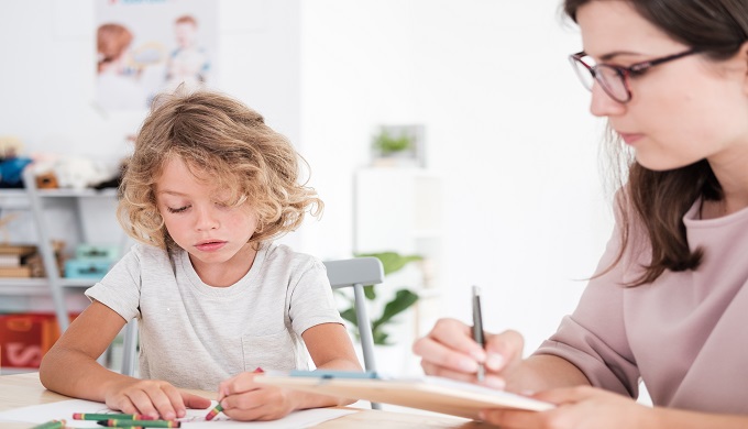 Child drawing pictures during meeting with therapist