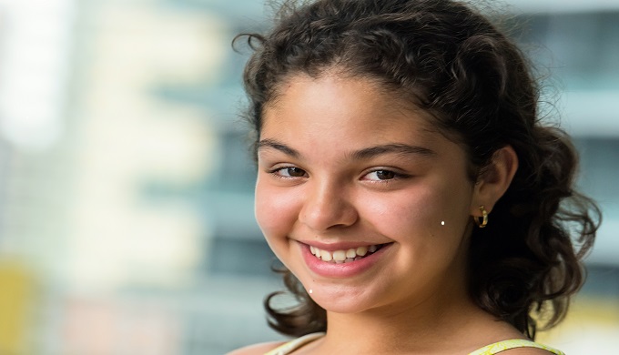 Lifestyle image of a Smiling Twelve Years Old Hispanic Girl looking at the camera
